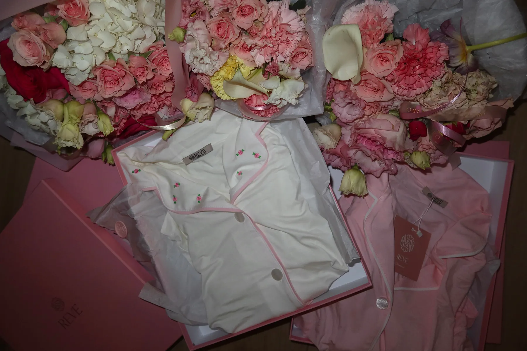 Pink gift boxes from @revesleepwear including monogrammed silk pajamas with pink piping, beautifully arranged for a Galentine’s dinner at Beefbar NYC.