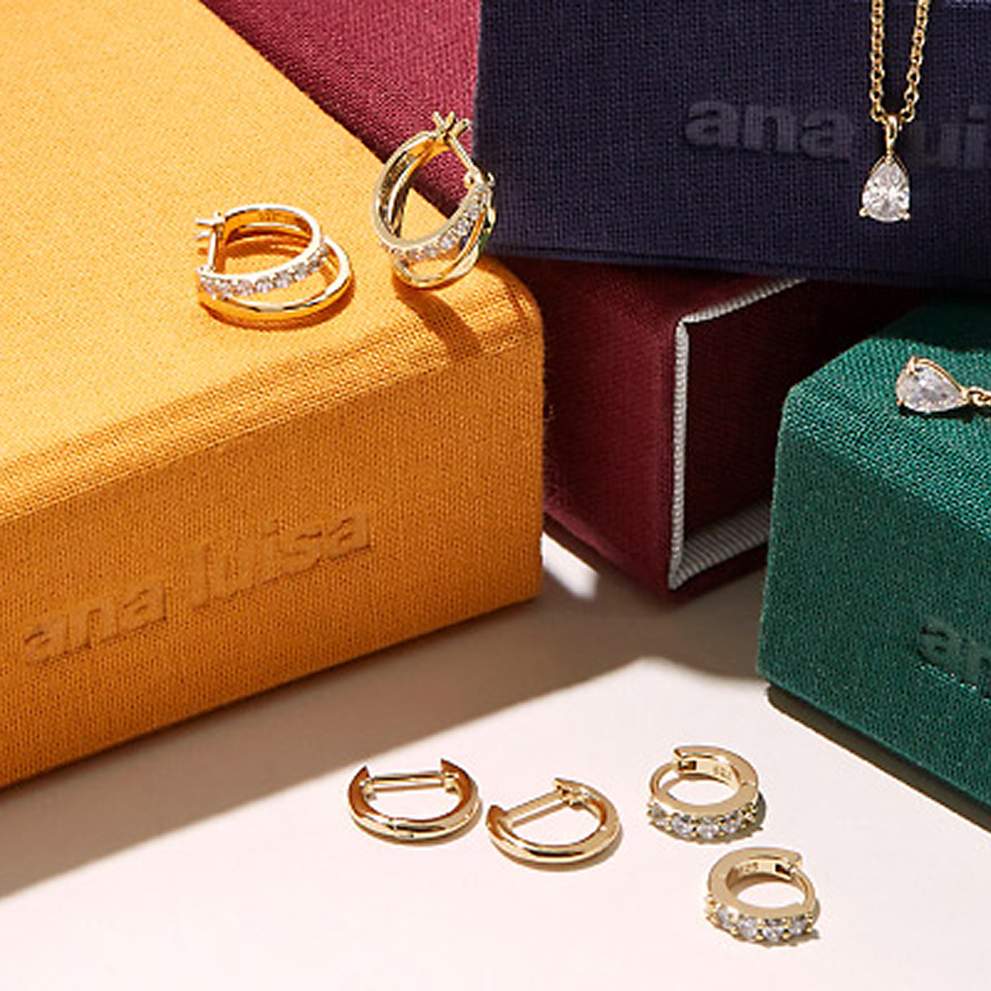 Ana Luisa earrings and necklace over their jewelry boxes