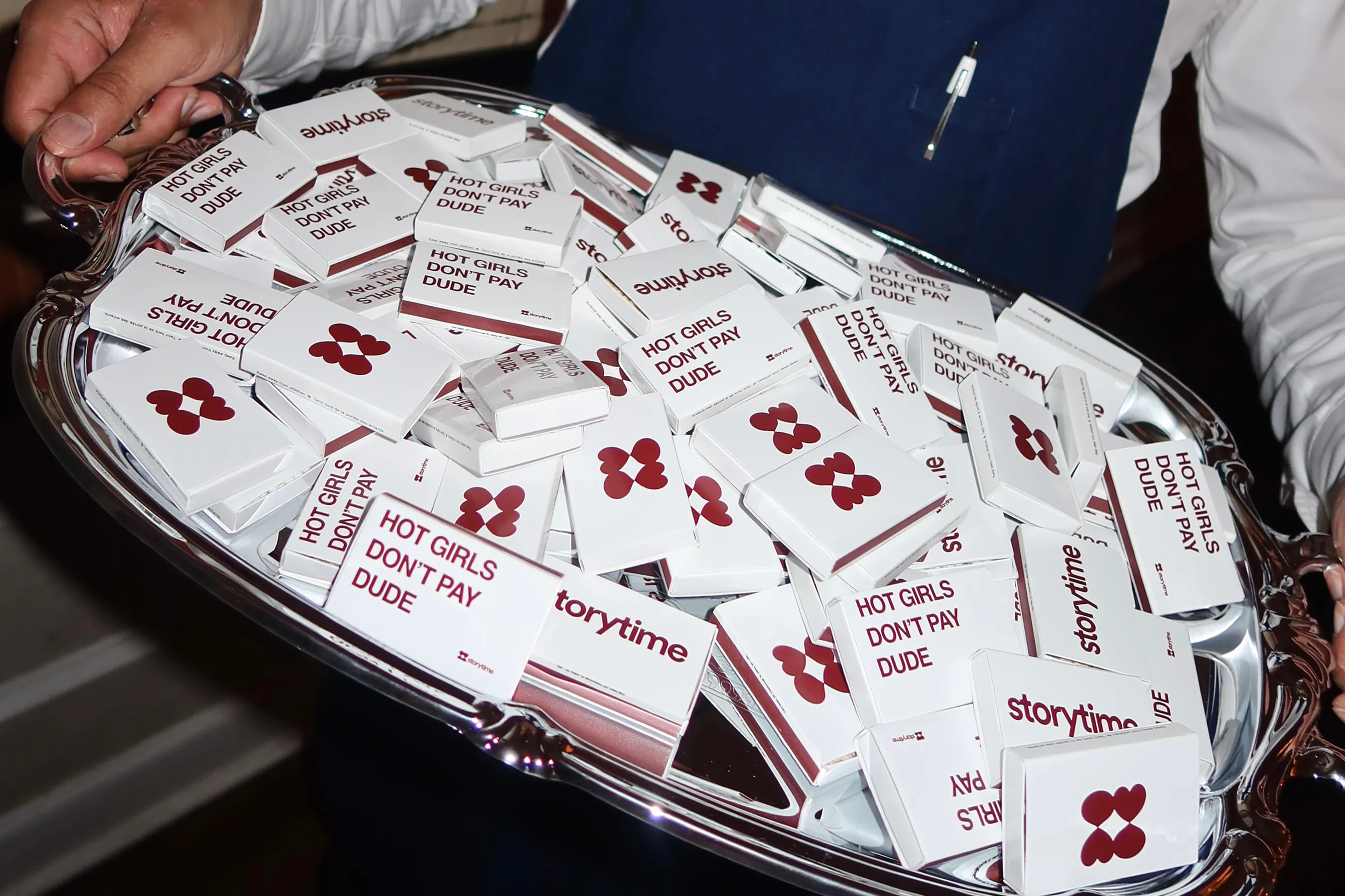 Silver tray filled with custom Storytime matchboxes, featuring the slogan “Hot girls don’t pay dude” alongside the Storytime logo.
