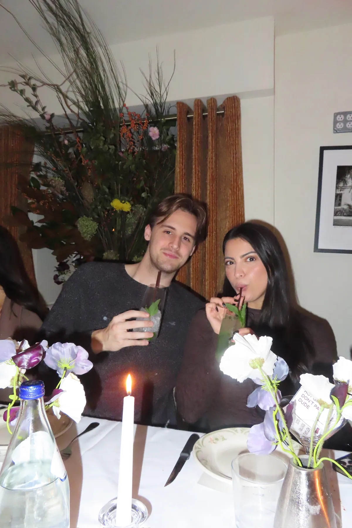 @thequeenfoodie and @williamjackman2 posing at Storytime influencer Friendsgiving dinner at Opto in New York city holding mojitos in their hands.