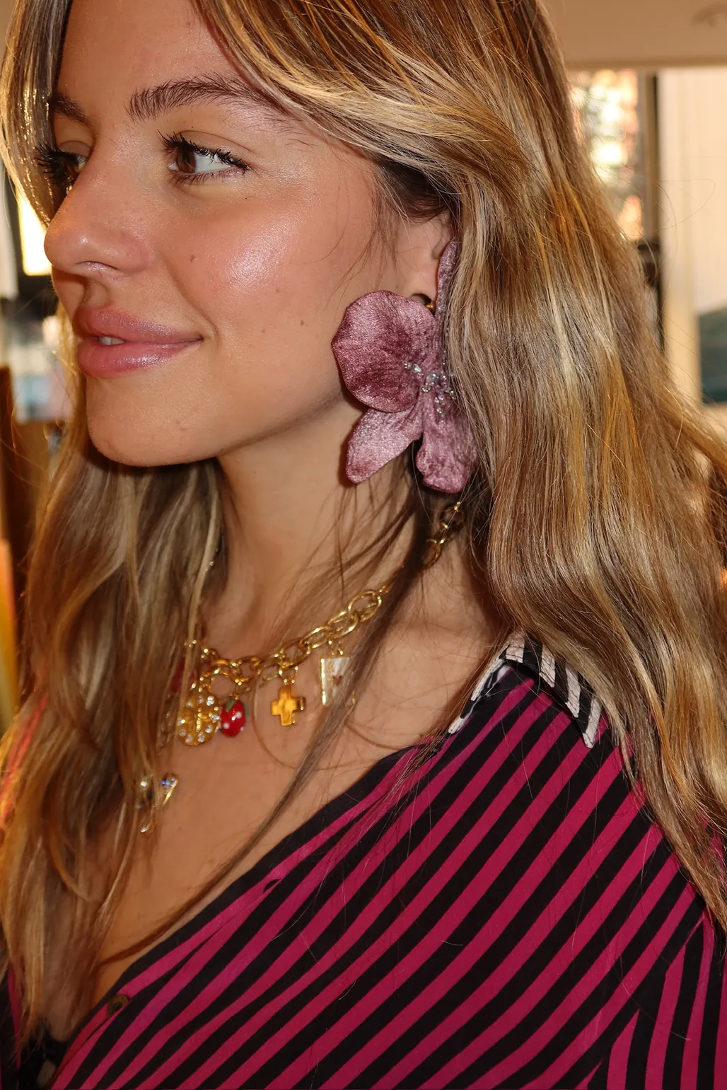 Close-up of a guest wearing a pink floral statement earring and layered jewelry at the Colombiamoda Oficial x Storytime launch in NYC.
