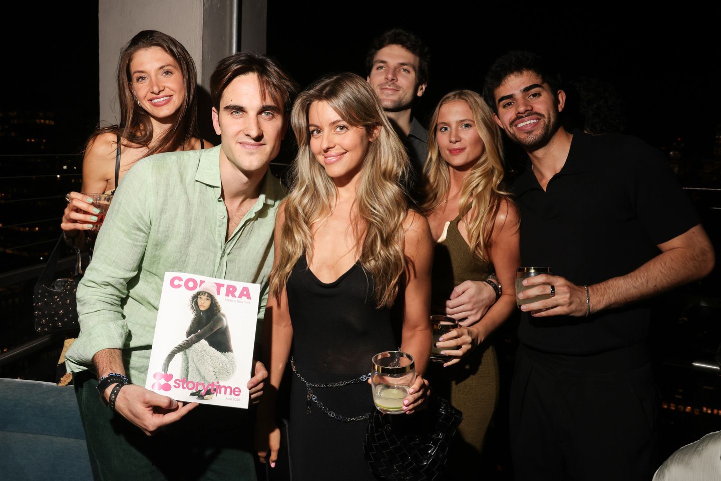 Group of friends posing with the Contra x Storytime magazine on a rooftop at the Made in New York event in NYC.