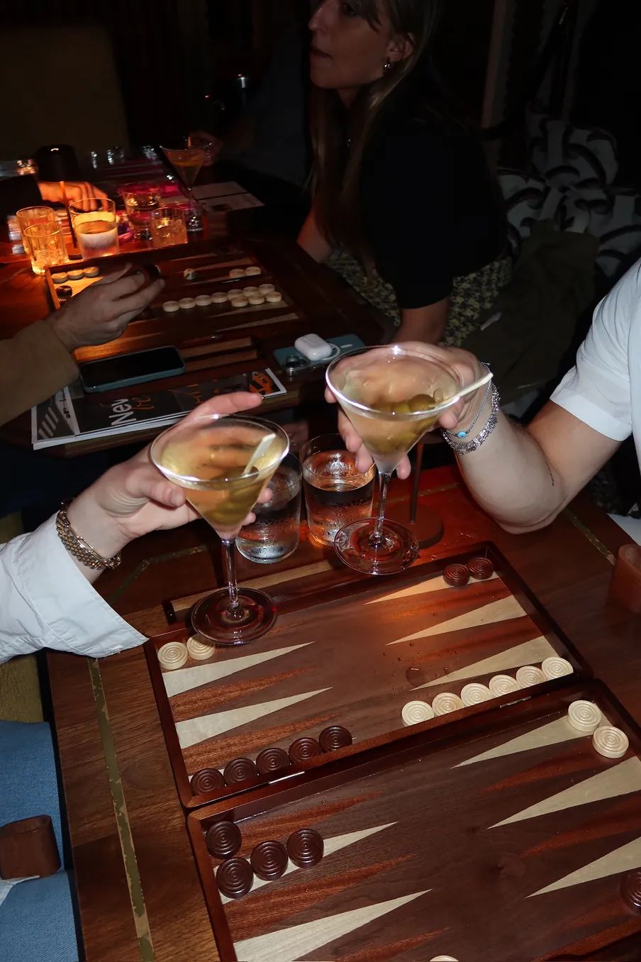 Guests toast cocktails over backgammon boards during the Storytime x Backgammon Social event at Beefbar NYC.