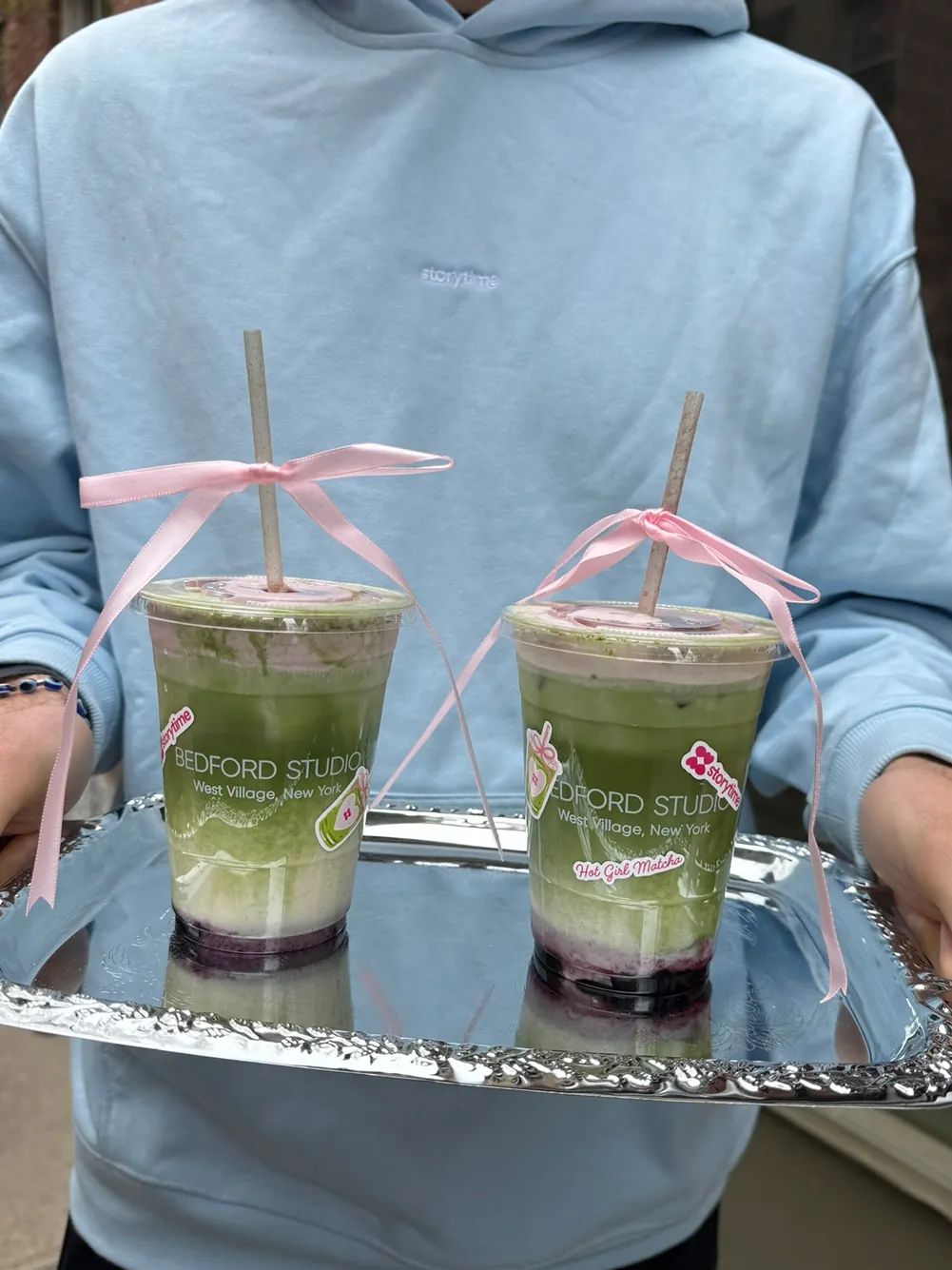Signature Hot Girl Matcha drinks made for the Storytime x Bedford Studios NYC collaboration are served on a silver tray with pink ribbon details in the West Village.