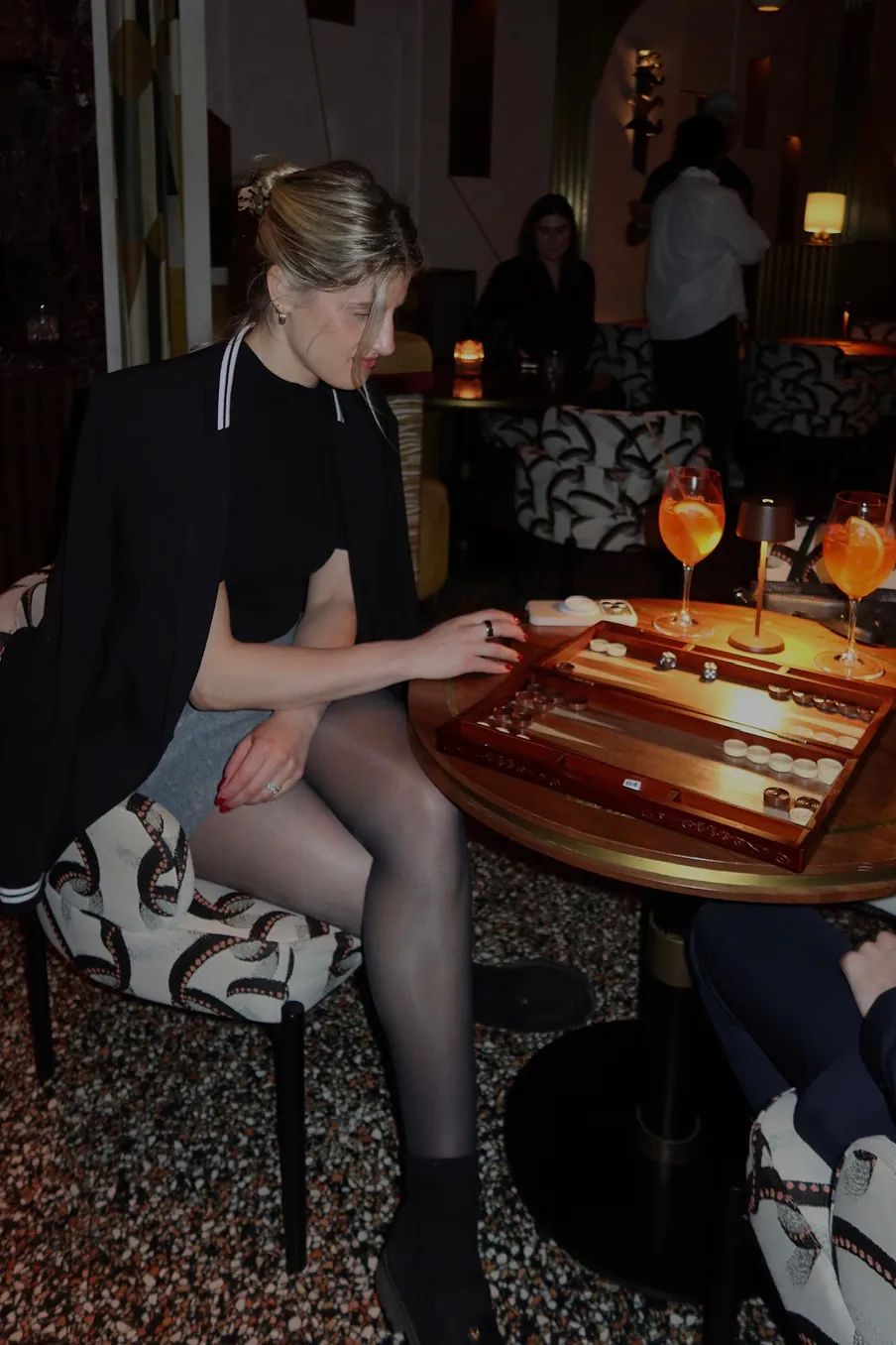 A guest plays backgammon while enjoying cocktails during the Storytime x Backgammon Social event at Beefbar NYC.