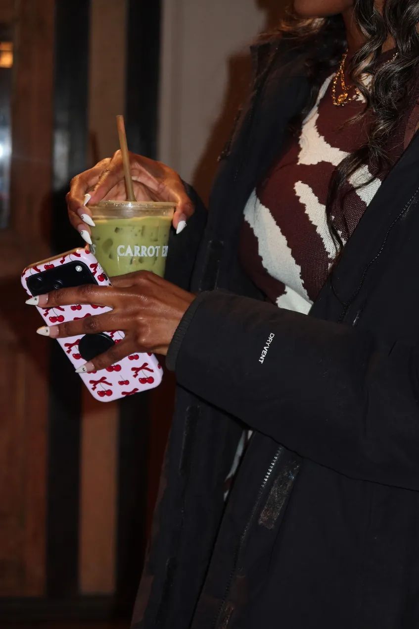 A guest holds an iced matcha drink during the Storytime event celebrating the opening of the new Carrot Express NoLita location in NYC.