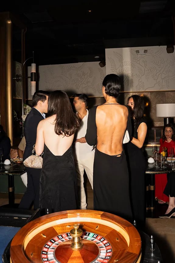 Guests and Storytime creators socializing beside a roulette table during Beefbar NYC’s 2-year anniversary casino night celebration in Manhattan.