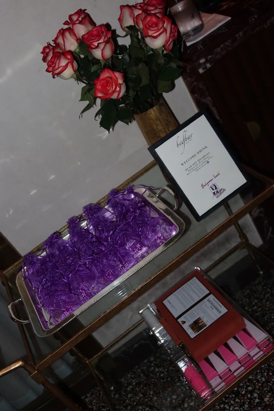 Event details, roses, and backgammon-themed gifts are displayed at the Storytime x Backgammon Social event hosted at Beefbar NYC.