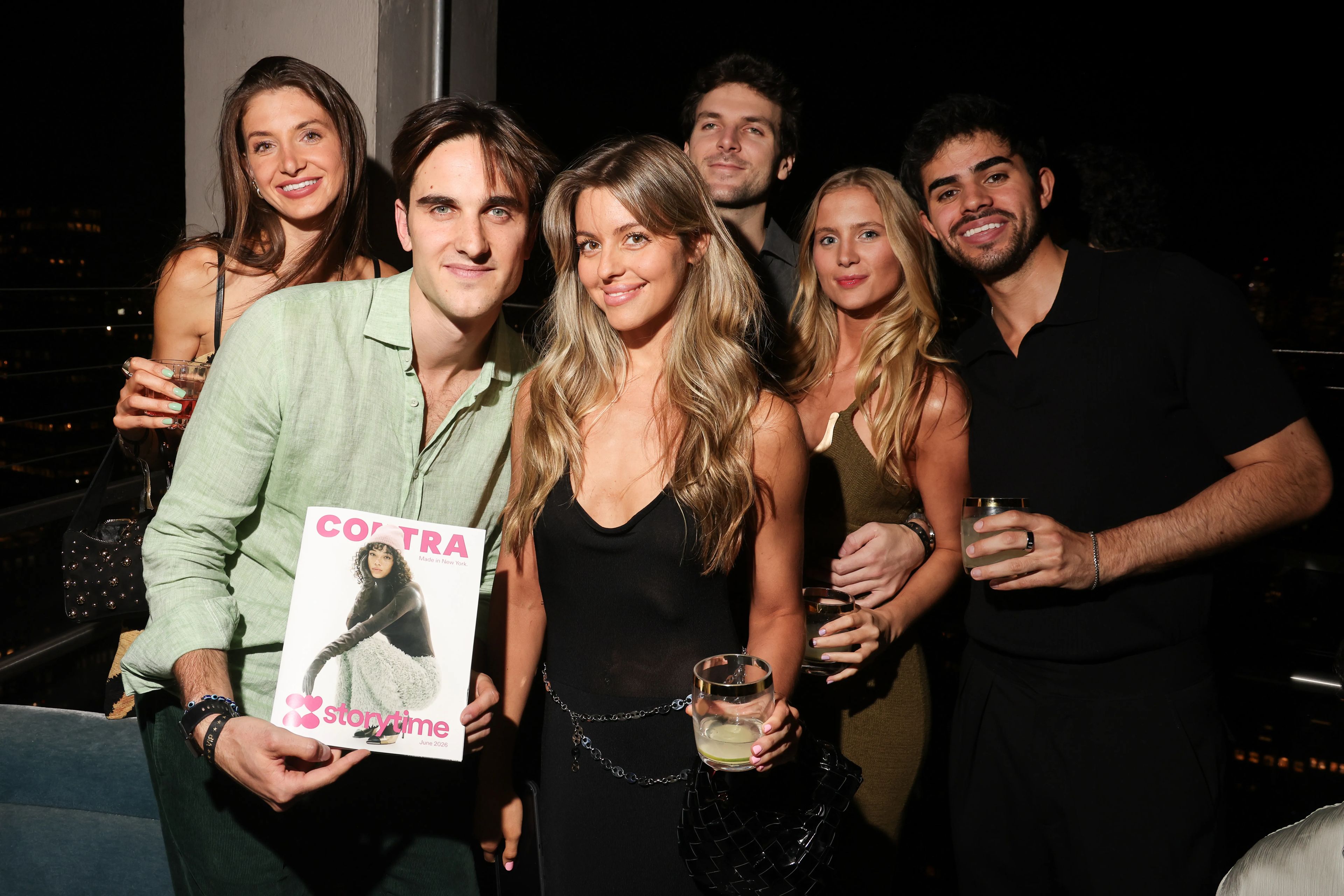Group of friends posing with the Contra x Storytime magazine on a rooftop at the Made in New York event in NYC.
