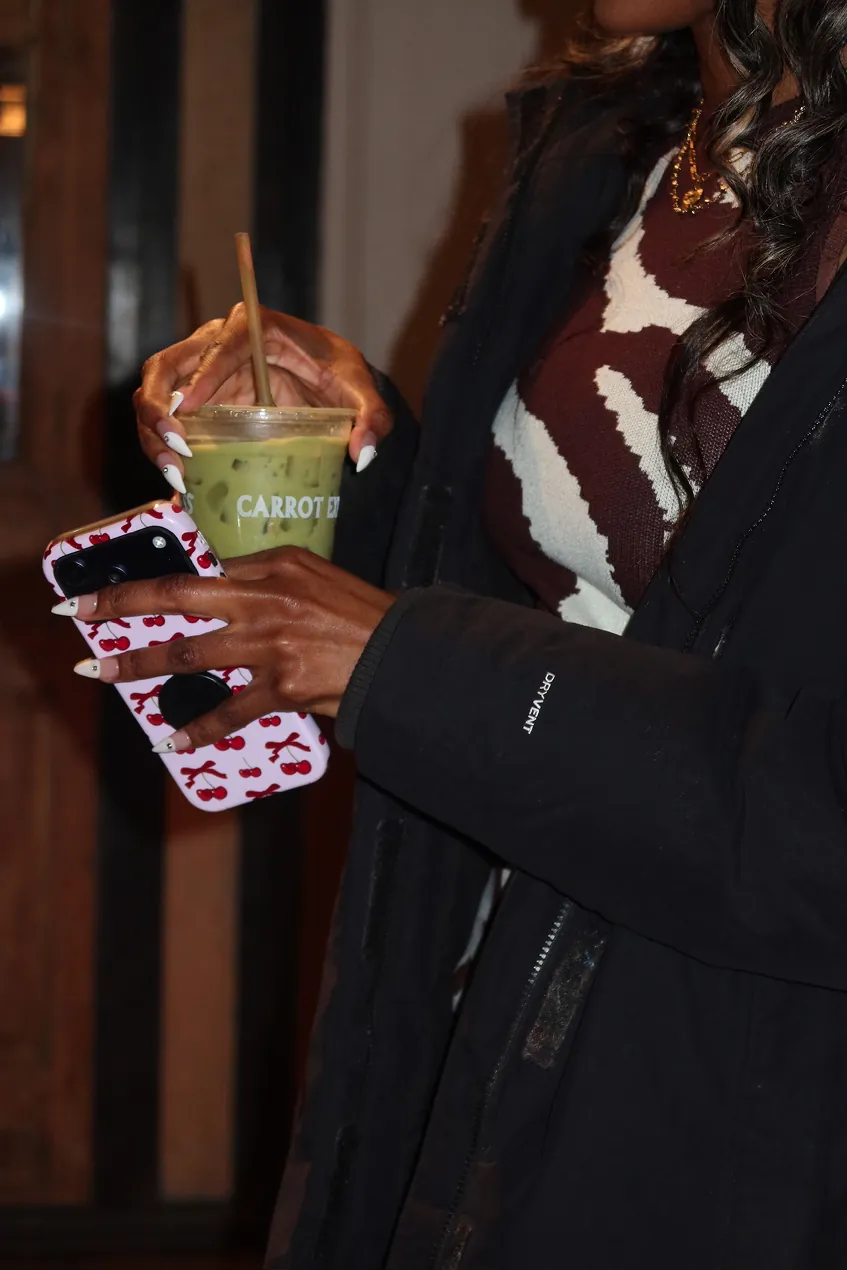 A guest holds an iced matcha drink during the Storytime event celebrating the opening of the new Carrot Express NoLita location in NYC.