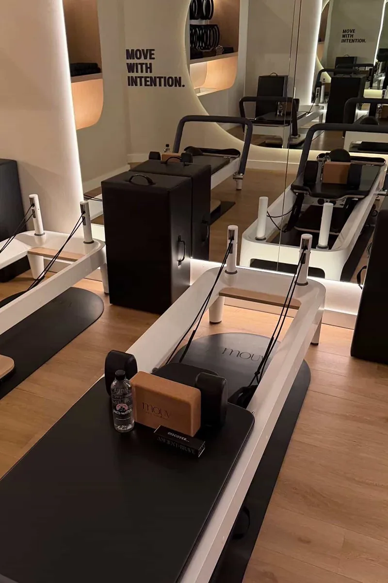 Modern reformer machines inside Mouv Pilates Studio prepared for a Storytime wellness event with Joe & The Juice in NYC.
